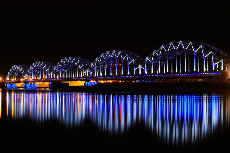 Illuminated bridge against clear blue sky at night
