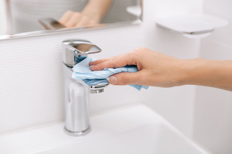 Cropped hand washing hands in bathroom
