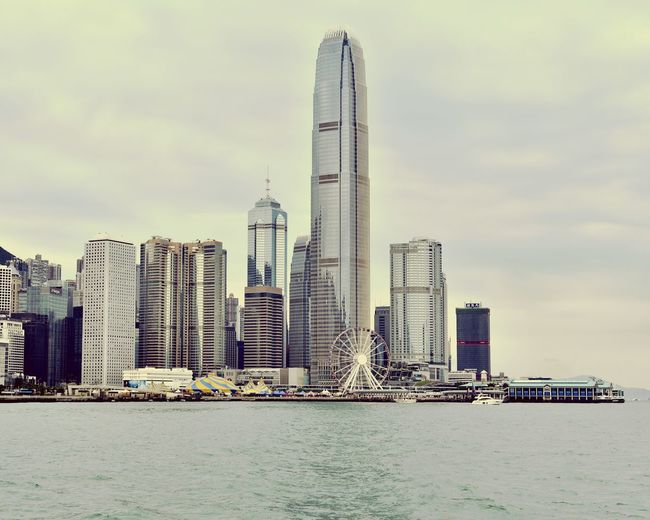 Sea by buildings against sky in city