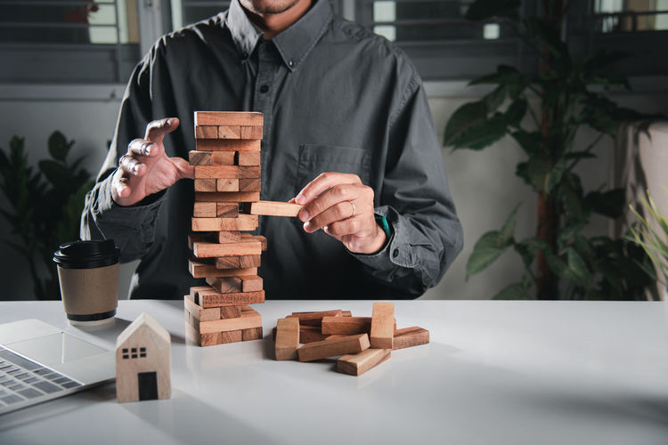 Midsection of businessman with toy blocks on table