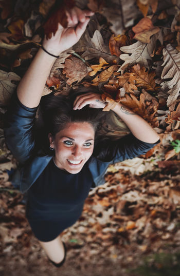 Portrait of a smiling young woman in autumn leaves