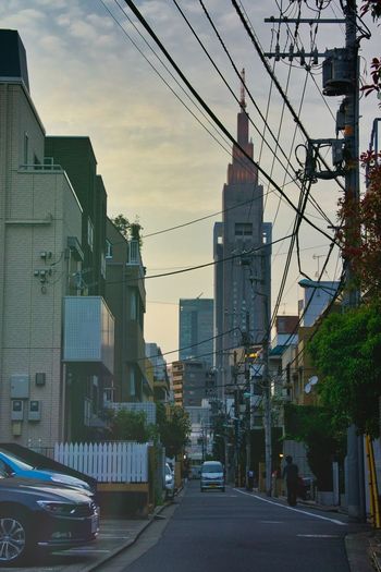 Street amidst buildings in city during sunset