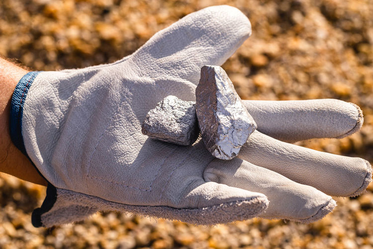Close-up of hands holding silver stones