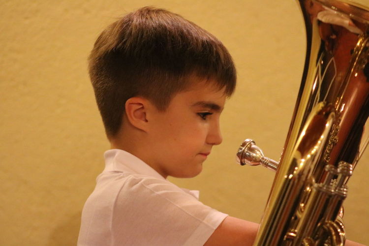Close-up of boy with trumpet against wall