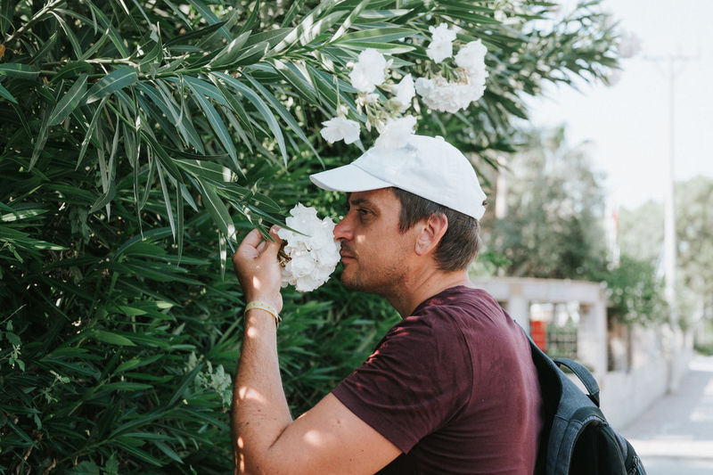 Mature real candid man traveler enjoys flowers on everyday moment. positive masculinity