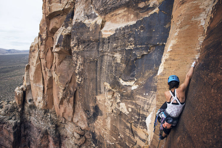 Young female hiker climbing rocky mountains at red rock canyon national conservation area
