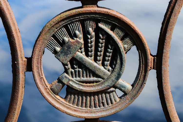 Close-up of rusty machine part against sky,the symbol of soviet union, ussr