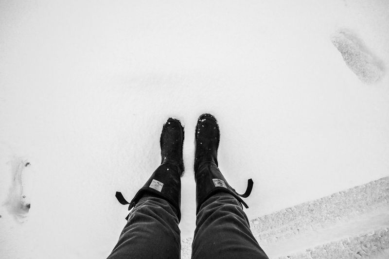 Low section of man standing on snow