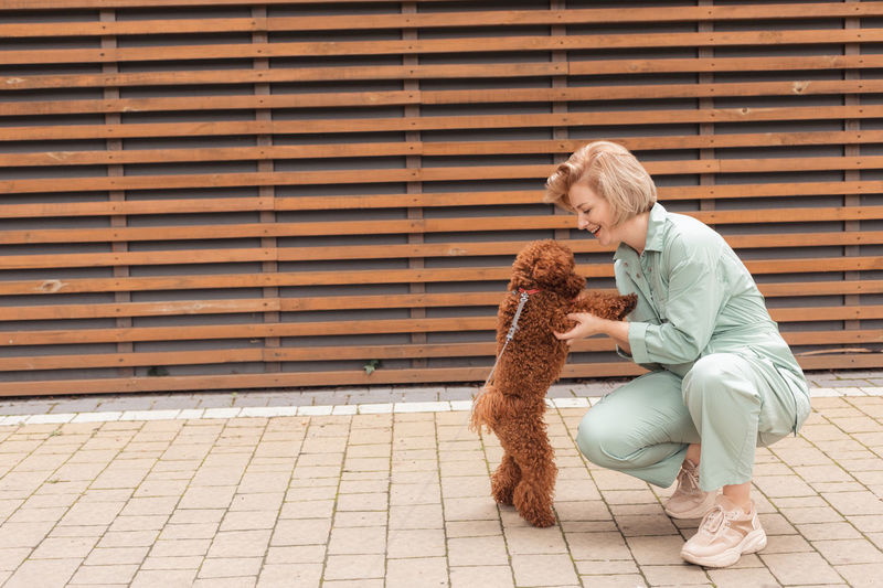 Man with dog sitting against wall