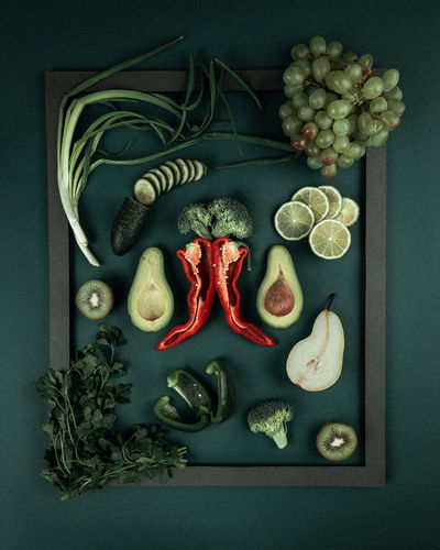 High angle view of green, red fruits and vegetables on table in the frame