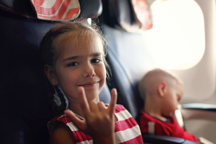 Smiling girl gesturing in plane