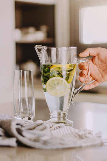 Cropped hand of woman holding wineglass on table