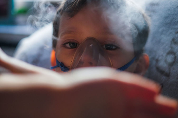 Close-up portrait of boy wearing oxygen mask