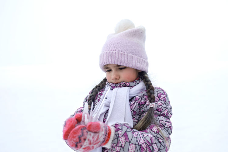 Cute girl holding icicle during winter