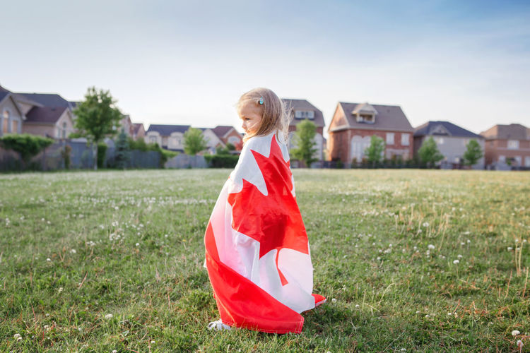 Rear view of girl wrapped in canadian flag