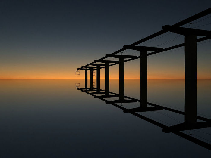 Built structure over sea during sunset