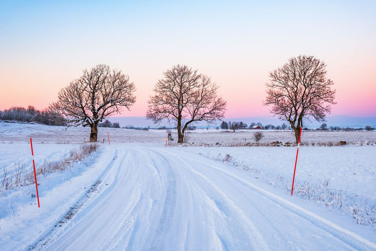 Sunset at a snowy winter road in the countryside
