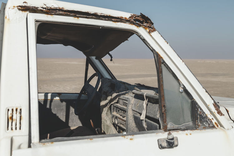 An old abandoned car in the desert in uae, closeup view through the window