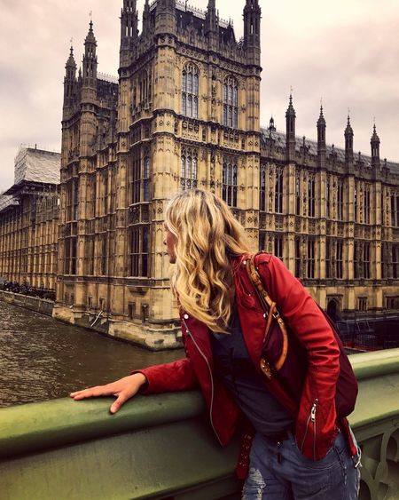 Young woman wearing leather jacket at westminster bridge in city