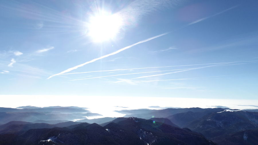 Scenic view of vapor trails against sky on sunny day