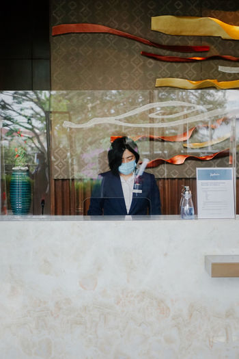 Receptionist wearing mask working in hotel