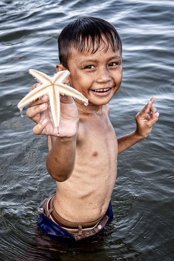 Portrait of smiling boy holding sea