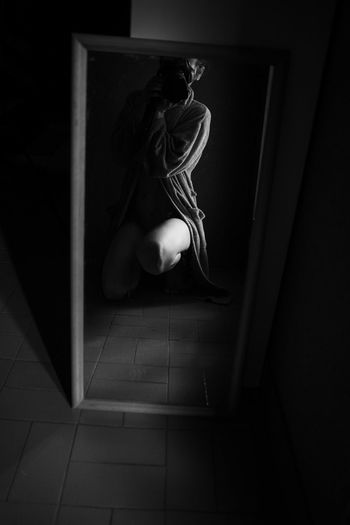 Low angle view of woman sitting on floor at home