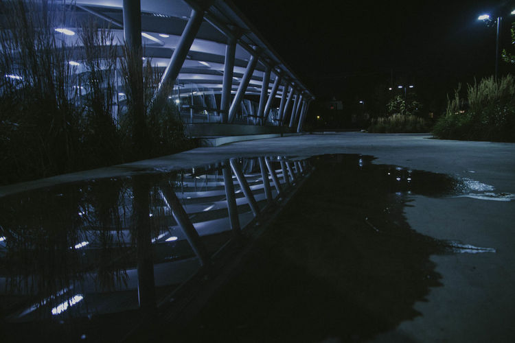 View of swimming pool by lake at night