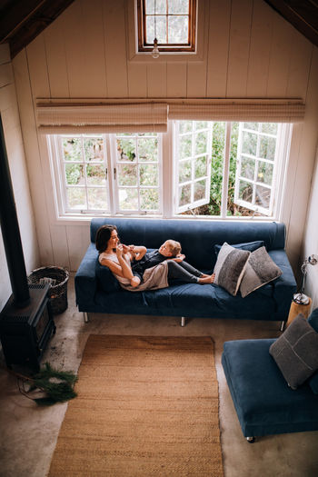 Cuddle Family Happiness Happy People Home Laughing Moments Mother Quality Time Boy Cabin Child Domestic Room Indoors Leisure Activity Lifestyles Living Room Mom Real People Relaxation Sitting Smile Toddler Togetherness Window Autumn Mood