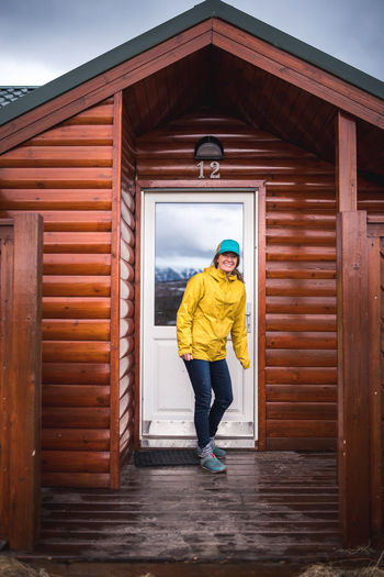 Woman in yellow jacket in front of house door in iceland