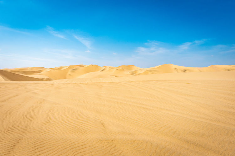 Scenic view of desert against blue sky