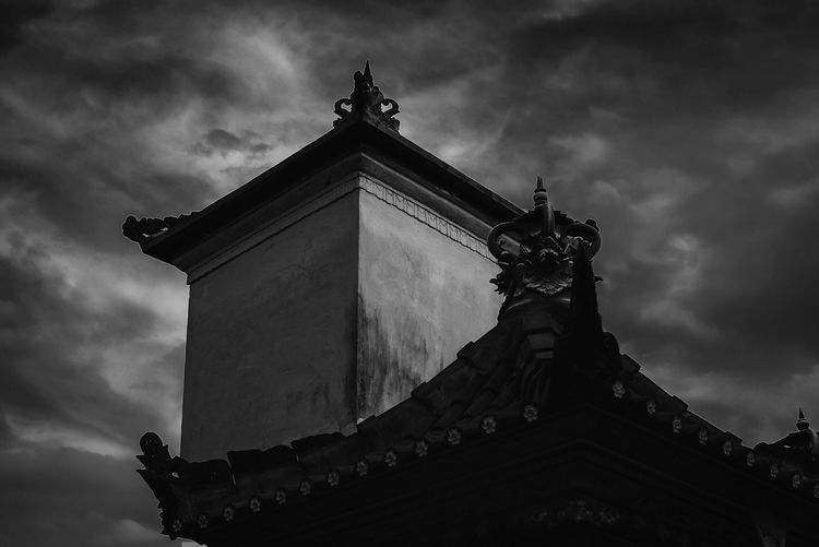 Low angle view of temple against cloudy sky
