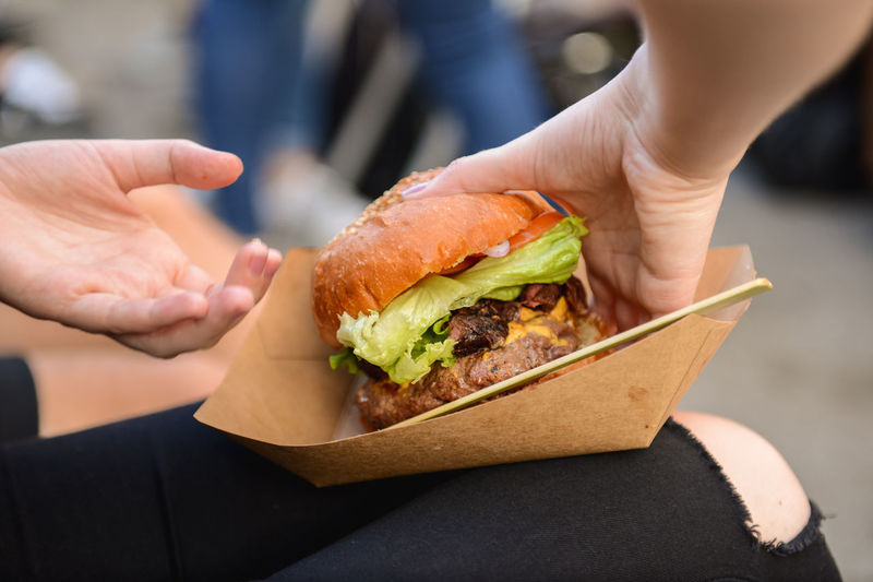 Cropped hands of woman holding burger