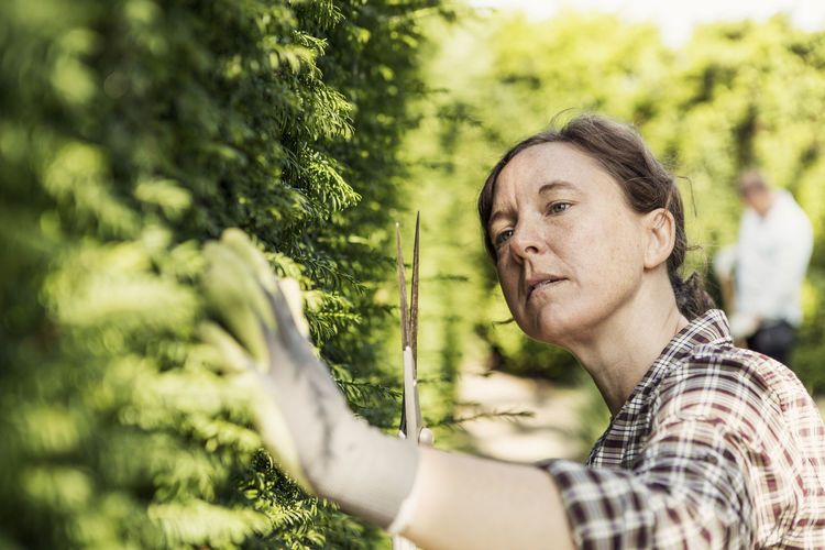 Woman examining plants at community garden