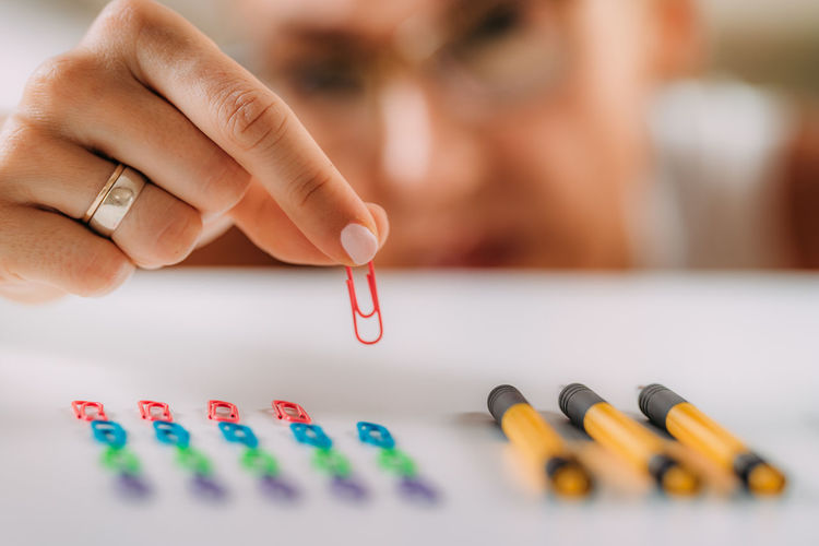 Woman with ocd. obsessive compulsive disorder concept. placing paperclips in a straight line.
