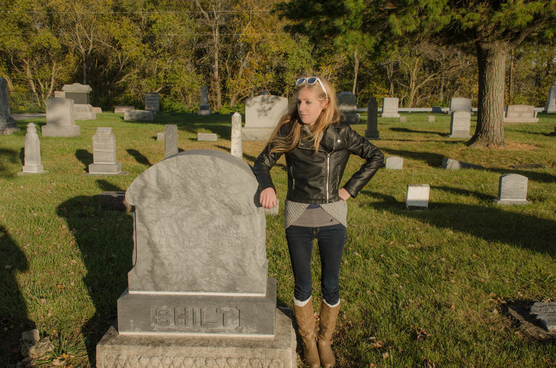 Young woman looking away while standing at cemetery