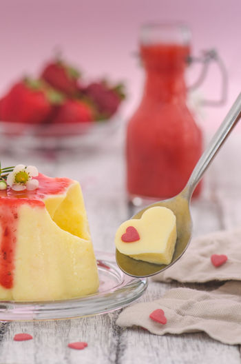 Close-up of heart shape pudding in spoon on table