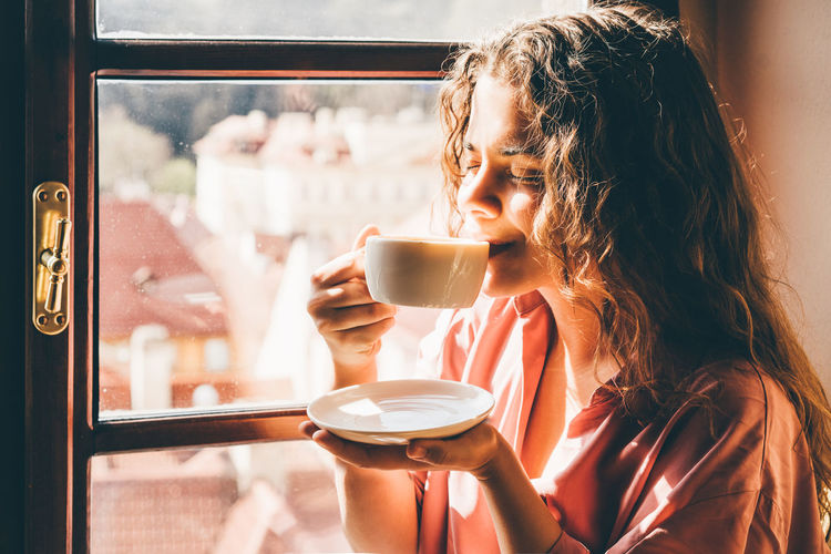 Portrait of woman drinking coffee in cup