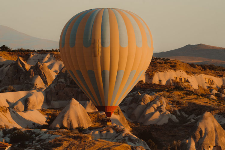 Hot air balloons on rock formation against sky