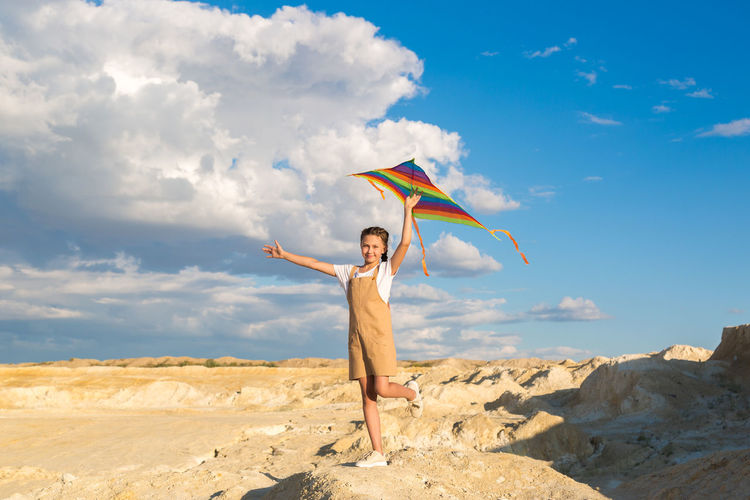 Portrait of a girl 8-9 years old with a kite standing on a mountain.