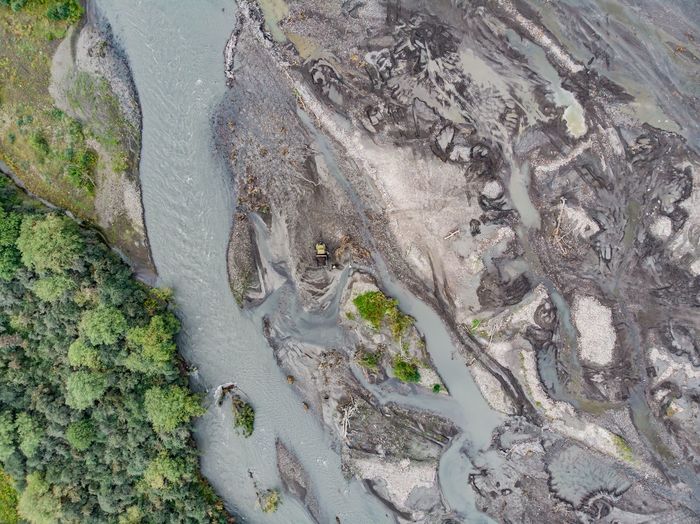Aerial view of river flowing by rocks and trees