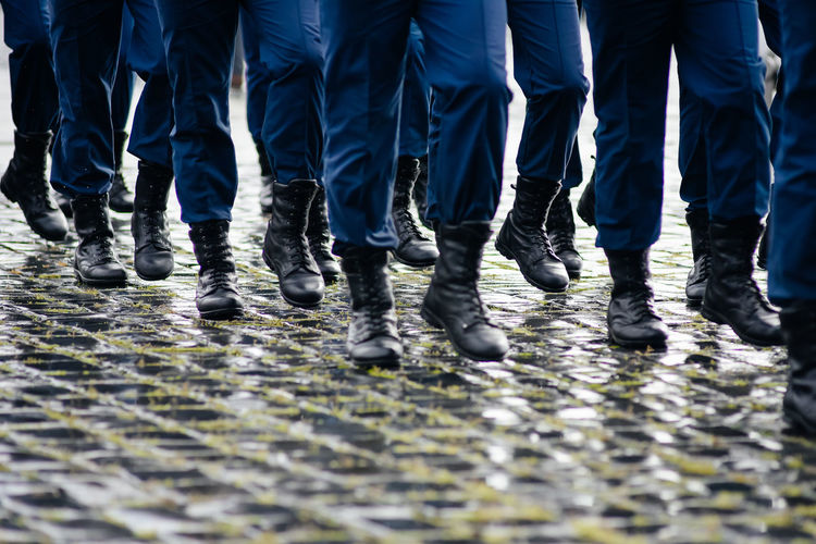 Low section of people in arm uniform on footpath
