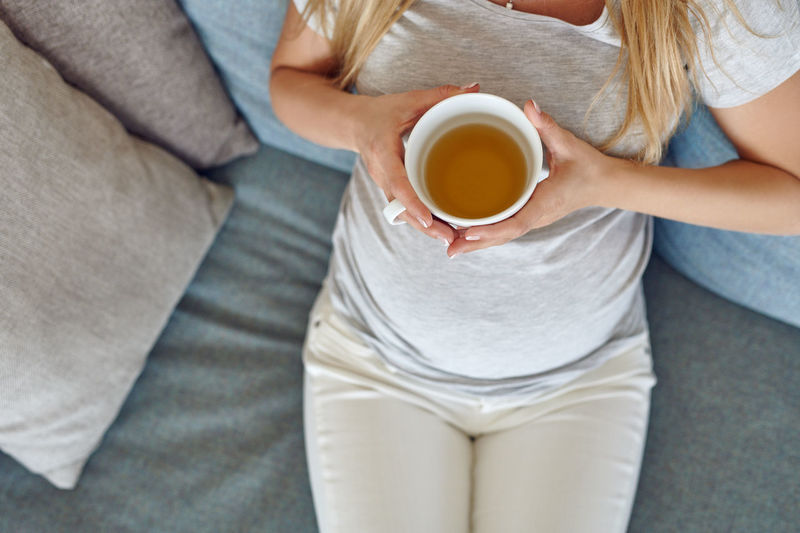 Midsection of woman holding coffee cup