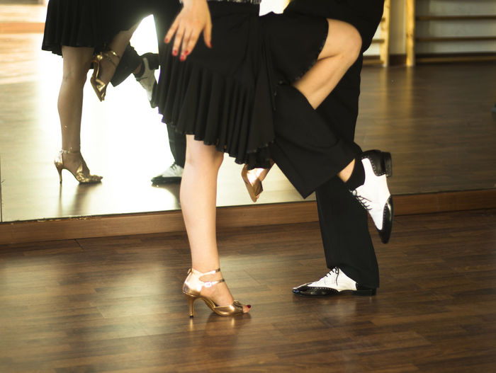 Low section of couple dancing on hardwood floor