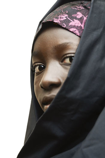 Close-up portrait of young woman against white background