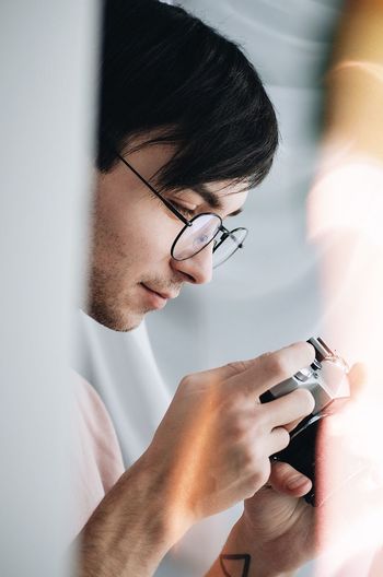 EyeEm Selects Eyeglasses Indoors One Person Holding Human Hand Human Body Part Real People Wireless Technology Lifestyles Young Adult Technology Day One Man Only Adult Men People