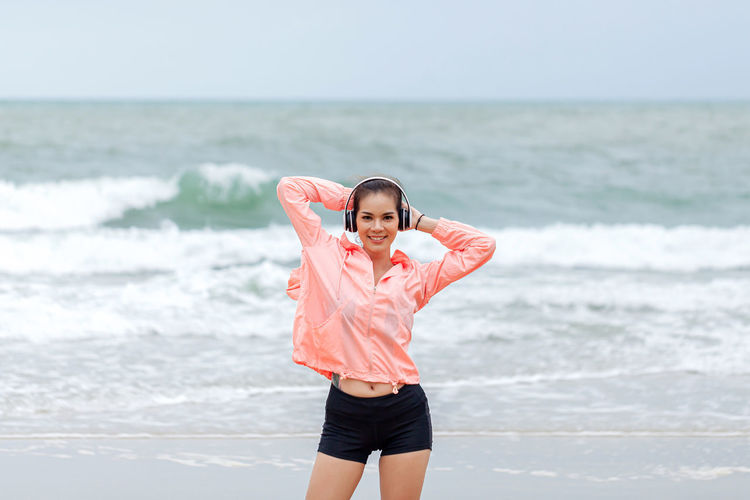 Full length of young woman standing at beach