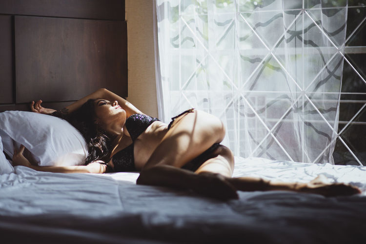 Seductive woman lying on bed