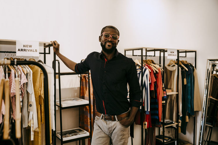 Portrait of smiling owner standing in clothing store