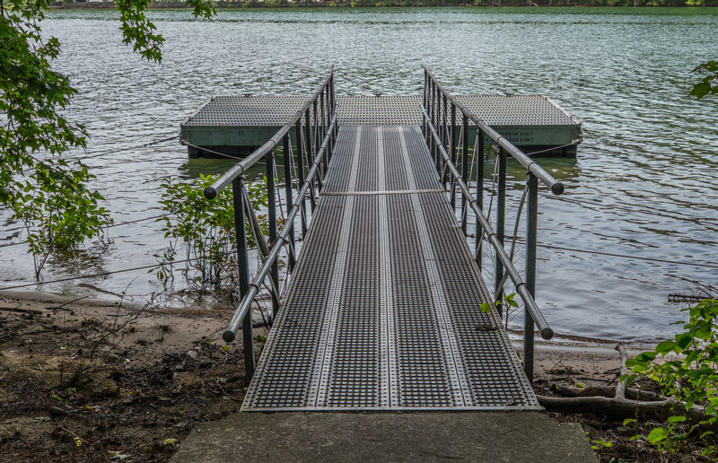 Empty jetty leading to pier over lake